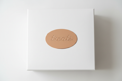 white box with treats label on on top in rose gold